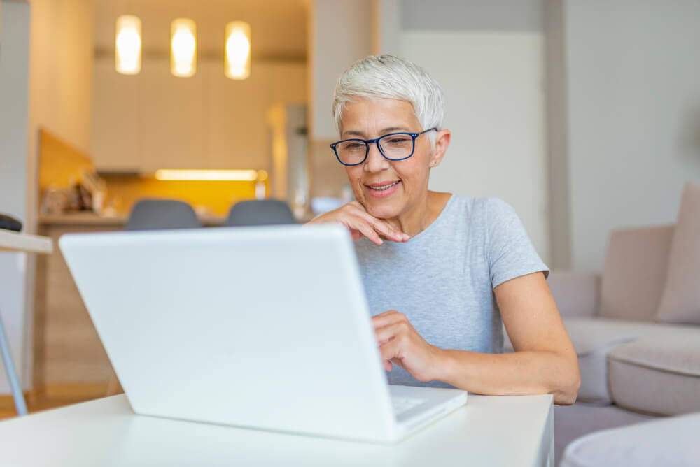 Older woman looking at computer wearing glasses