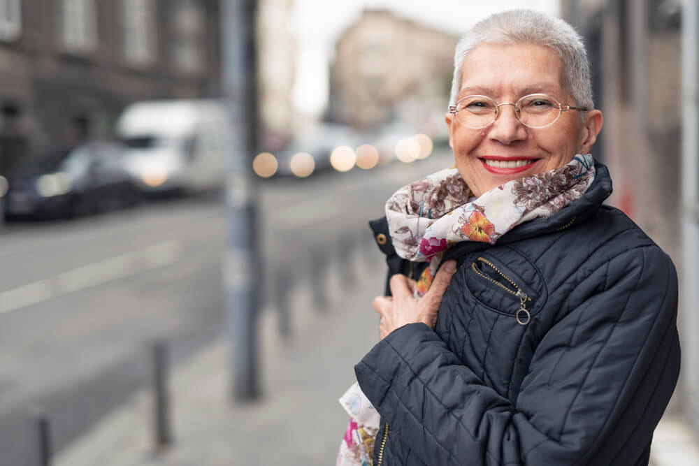 older woman in glasses and scarf on city street